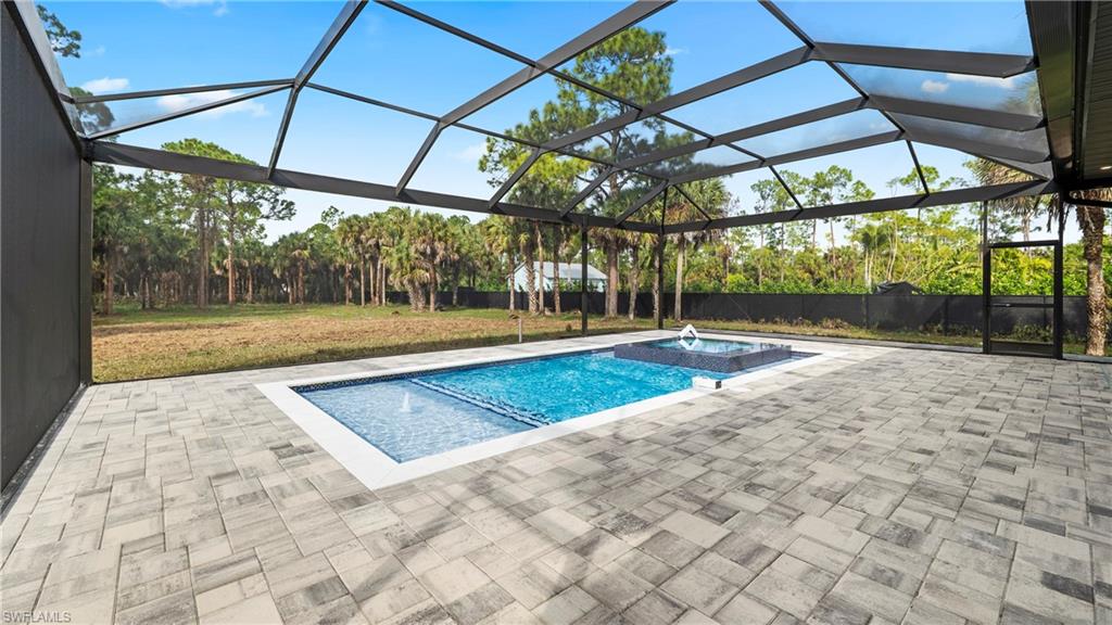 1687 19th Street Southwest Naples, FL 34117 - Photo 35 of 50 Fenced backyard with a lanai, a sunroom, and a patio