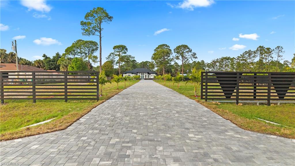 1687 19th Street Southwest Naples, FL 34117 - Photo 40 of 50 View of community with decorative driveway and view of wooded area