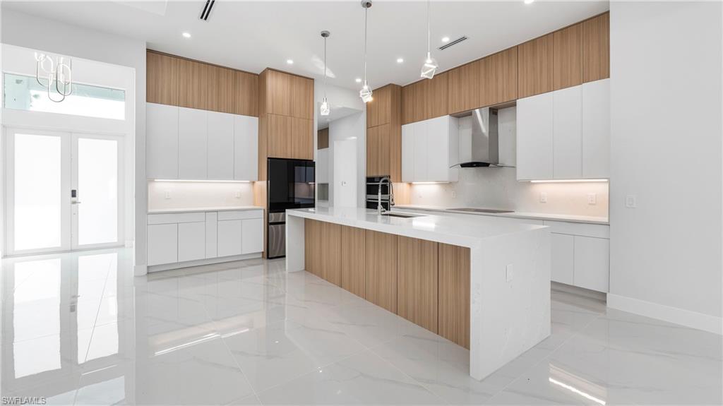 1687 19th Street Southwest Naples, FL 34117 - Photo 6 of 50 a kitchen with stainless steel appliances kitchen island granite countertop a refrigerator and a sink