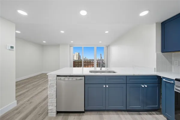 a view of kitchen with kitchen island granite countertop a stove top oven and a sink with granite countertops