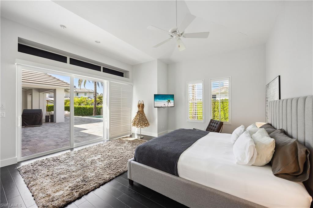 299 Mermaids Bight Naples, FL 34103 - Photo 12 of 28 a bedroom with a large bed and a large window