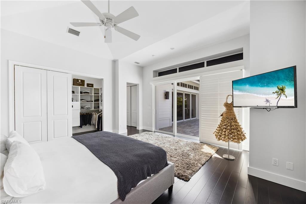 299 Mermaids Bight Naples, FL 34103 - Photo 13 of 28 a bedroom with a bed and dresser with wooden floor