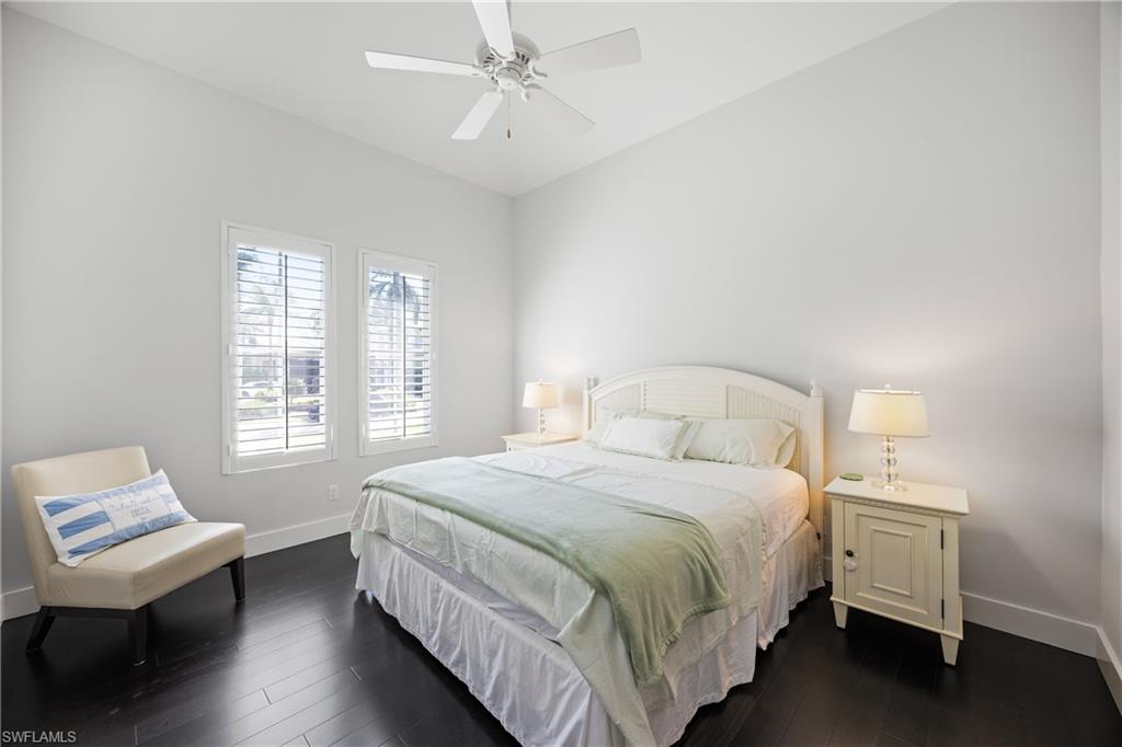 299 Mermaids Bight Naples, FL 34103 - Photo 20 of 28 a bedroom with a bed wooden floor and window