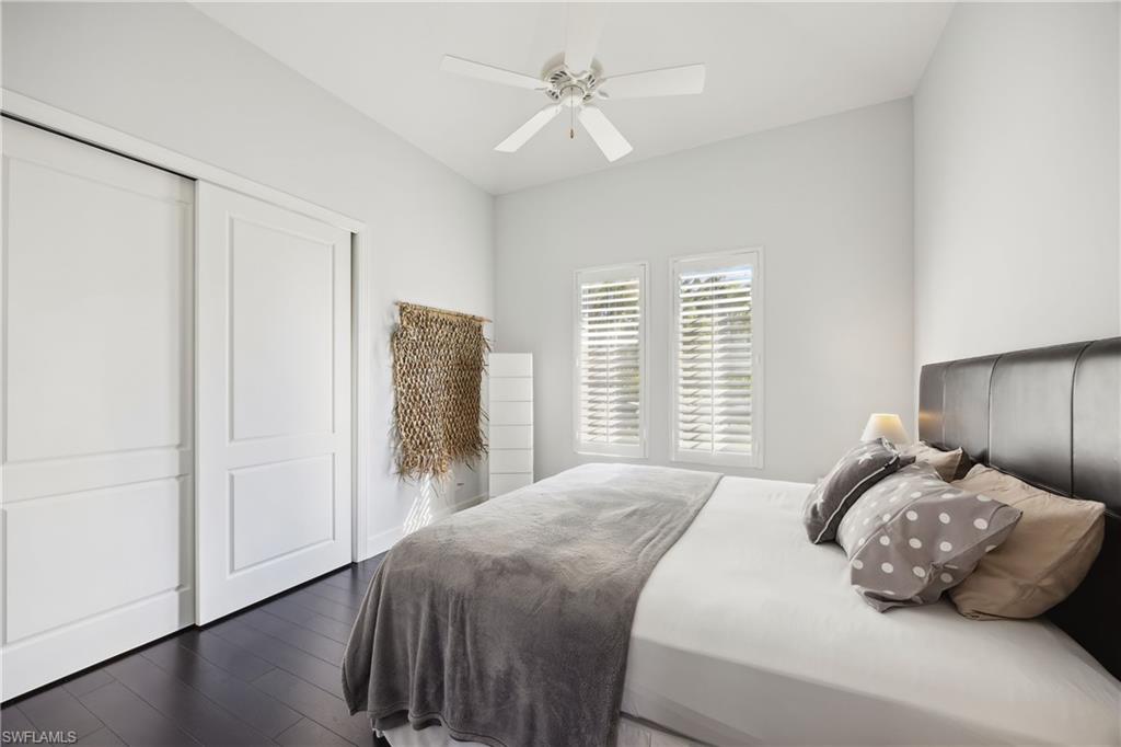 299 Mermaids Bight Naples, FL 34103 - Photo 21 of 28 a bedroom with a bed and a chandelier