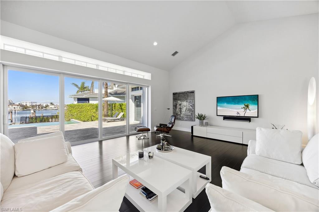 299 Mermaids Bight Naples, FL 34103 - Photo 9 of 28 a living room with furniture and a flat screen tv