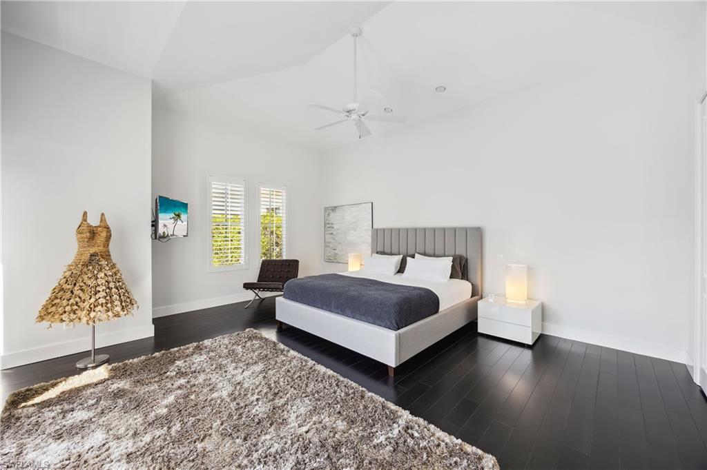 299 Mermaids Bight Naples, FL 34103 - Photo 10 of 28 a bedroom with a bed and wooden floor
