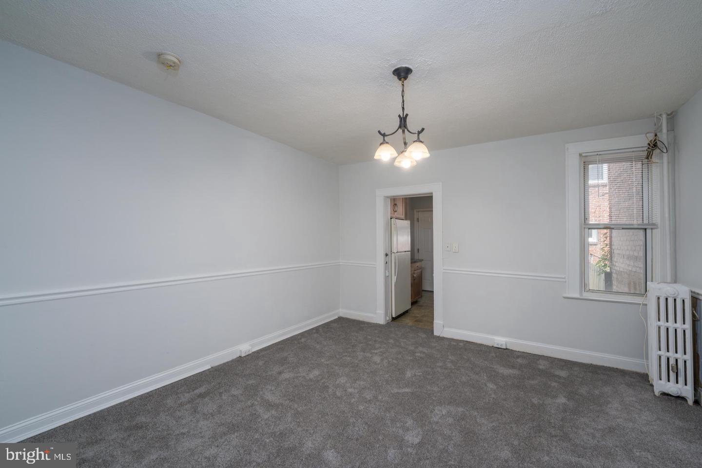 1637 Spence Street Baltimore, MD 21230 - Photo 7 of 22 an empty room with chandelier fan and windows