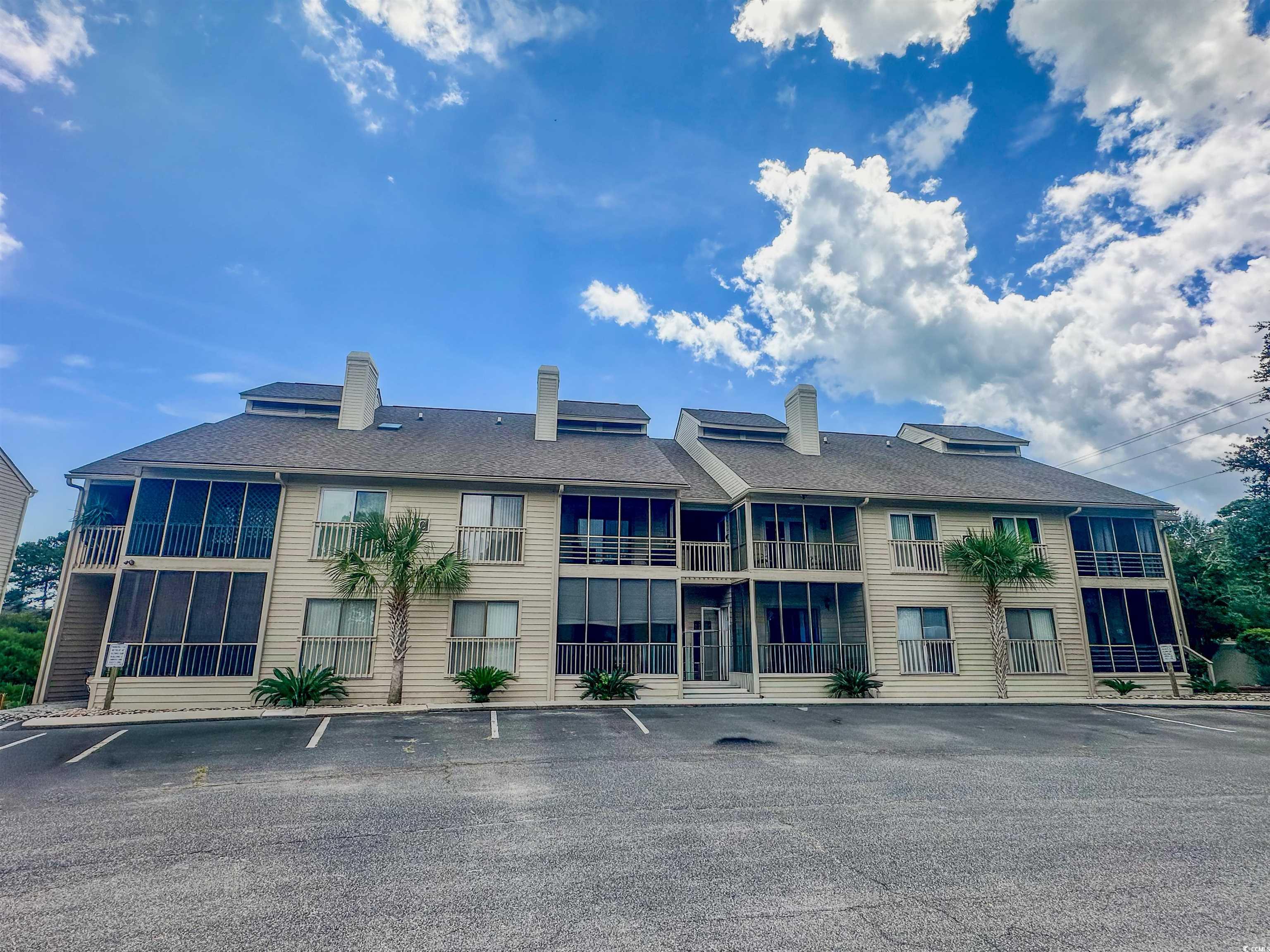View of building exterior featuring uncovered parking