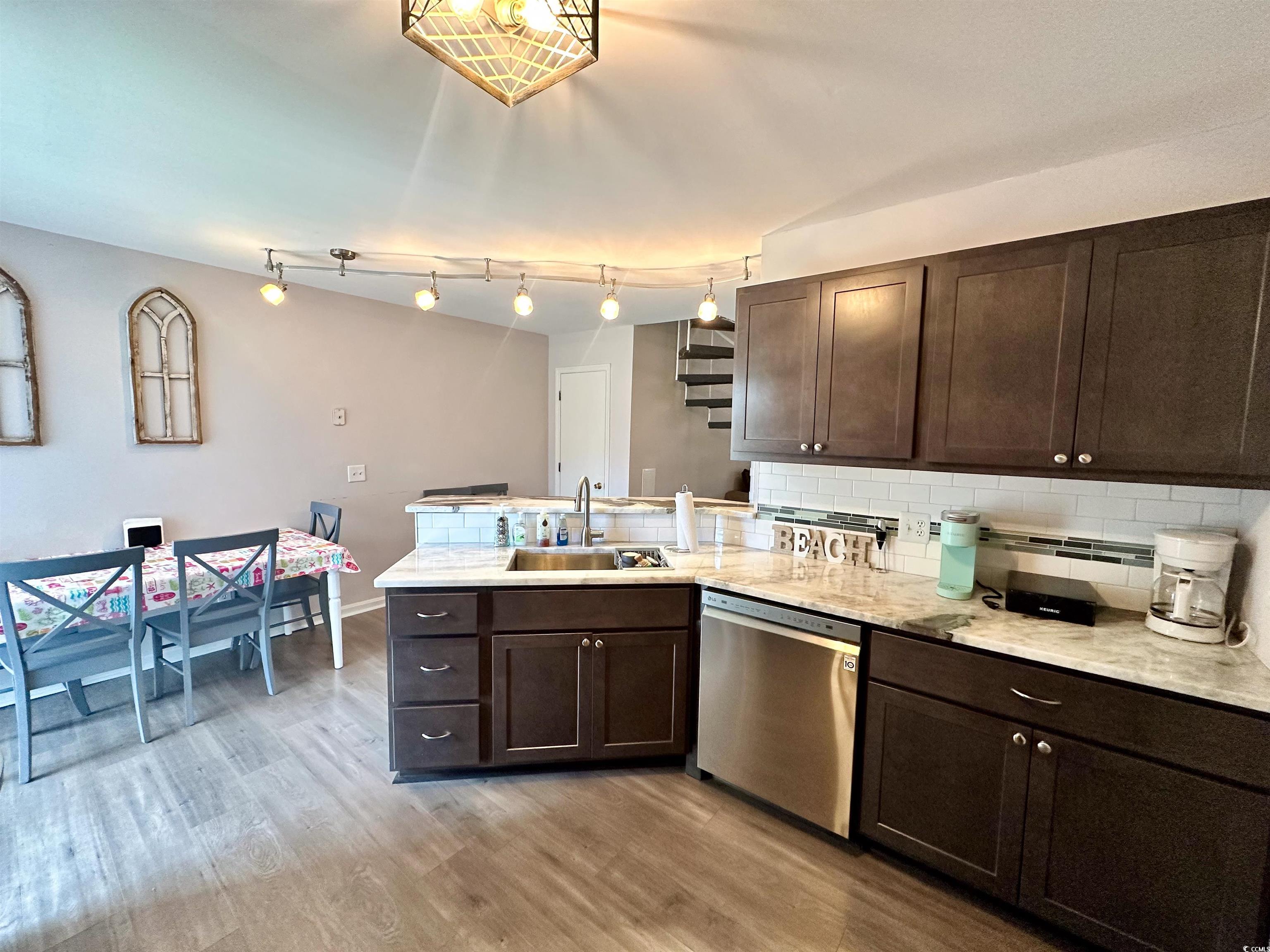 1356 Glenns Bay Road, Unit C202 Surfside Beach, SC 29575 - Photo 10 of 35 Kitchen with backsplash, stainless steel appliances, dark brown cabinets, light wood finished floors, and light stone countertops