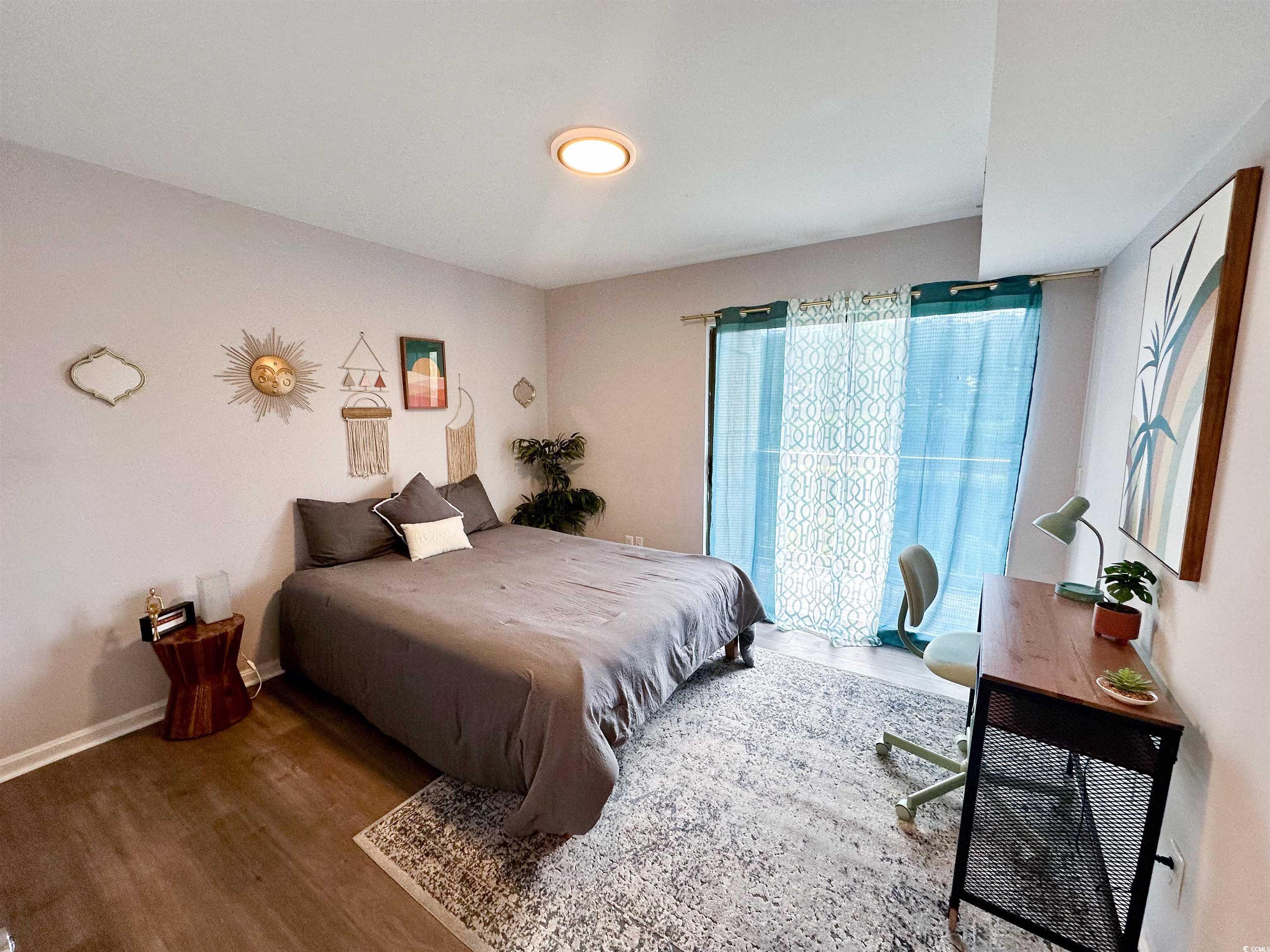 1356 Glenns Bay Road, Unit C202 Surfside Beach, SC 29575 - Photo 12 of 35 Kitchen with appliances with stainless steel finishes, a peninsula, a kitchen bar, light wood finished floors, and light stone counters