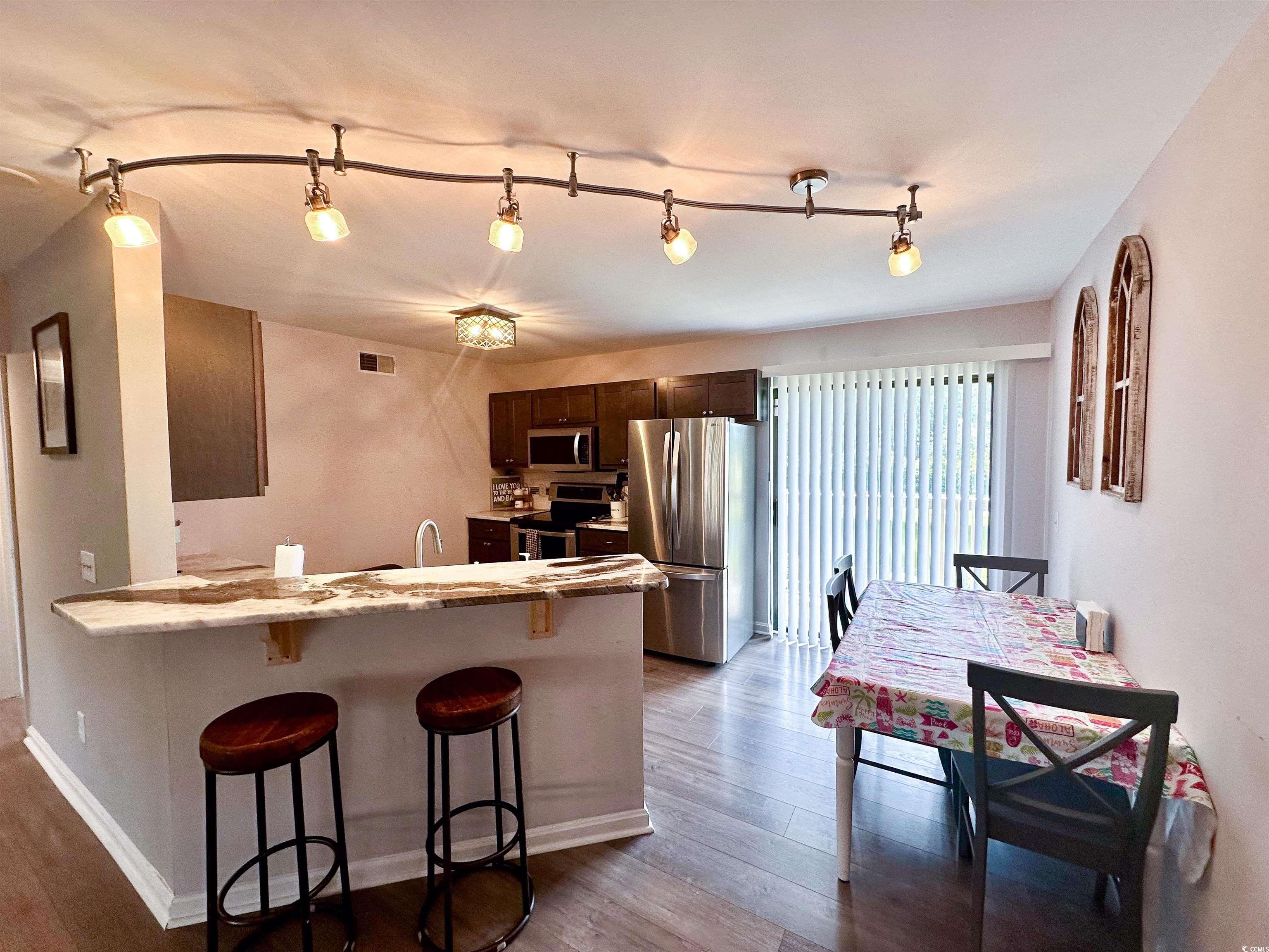 1356 Glenns Bay Road, Unit C202 Surfside Beach, SC 29575 - Photo 7 of 35 Living room featuring stairway, wood finished floors, and a high end fireplace