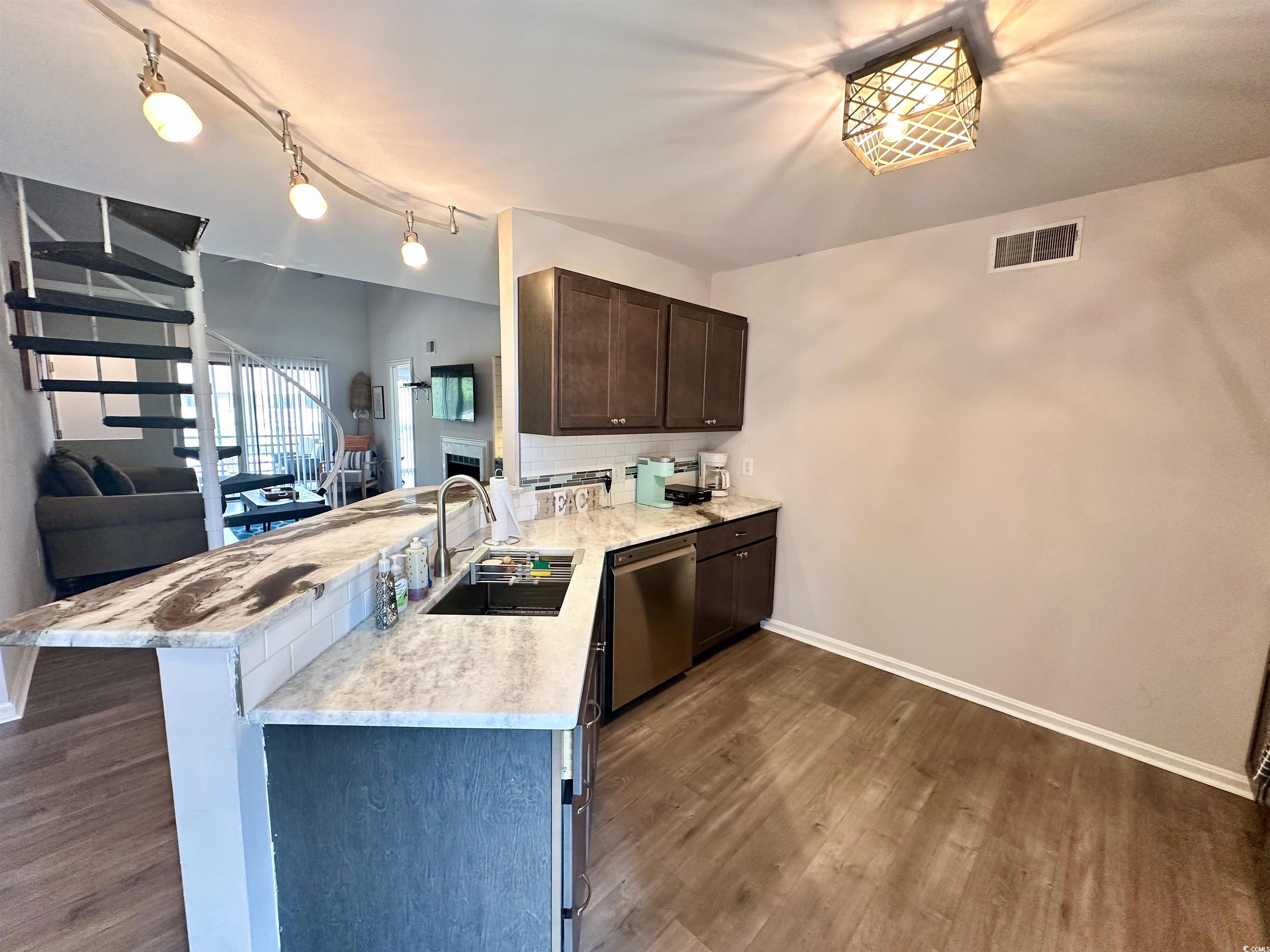 1356 Glenns Bay Road, Unit C202 Surfside Beach, SC 29575 - Photo 34 of 35 Kitchen with a peninsula, dark brown cabinetry, open floor plan, dark wood-style floors, and stainless steel dishwasher