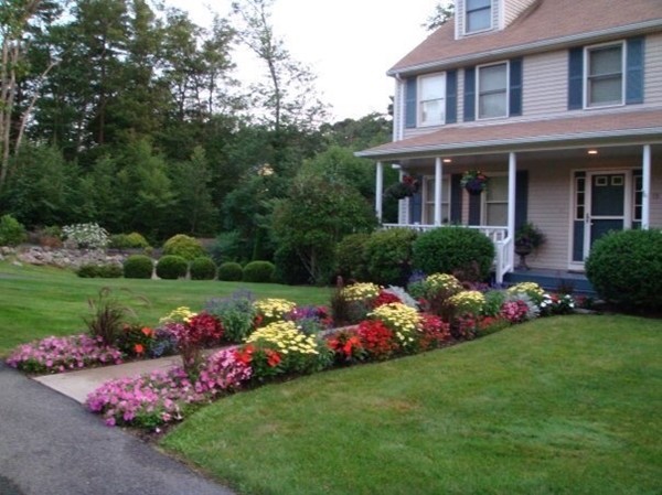 a front view of a house with a big yard and potted plants