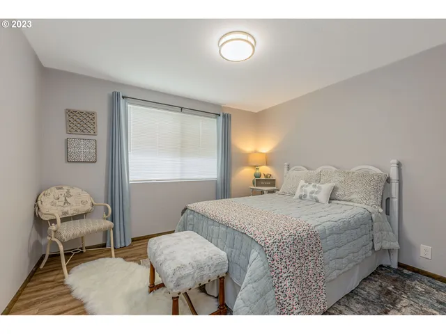 a bedroom with a bed window and chair