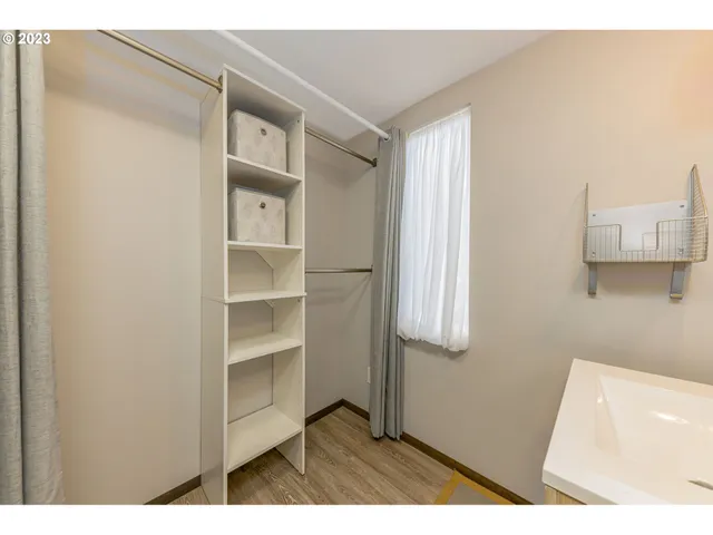 a picture of a room with wooden floor and cabinet