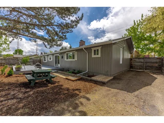 a backyard of a house with table and chairs