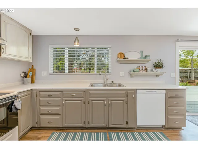 a kitchen with cabinets appliances and a window