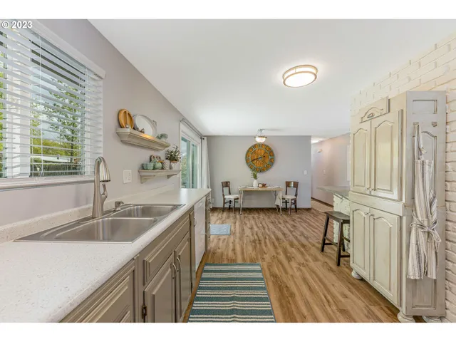 a kitchen view with wooden floor a sink and a stove