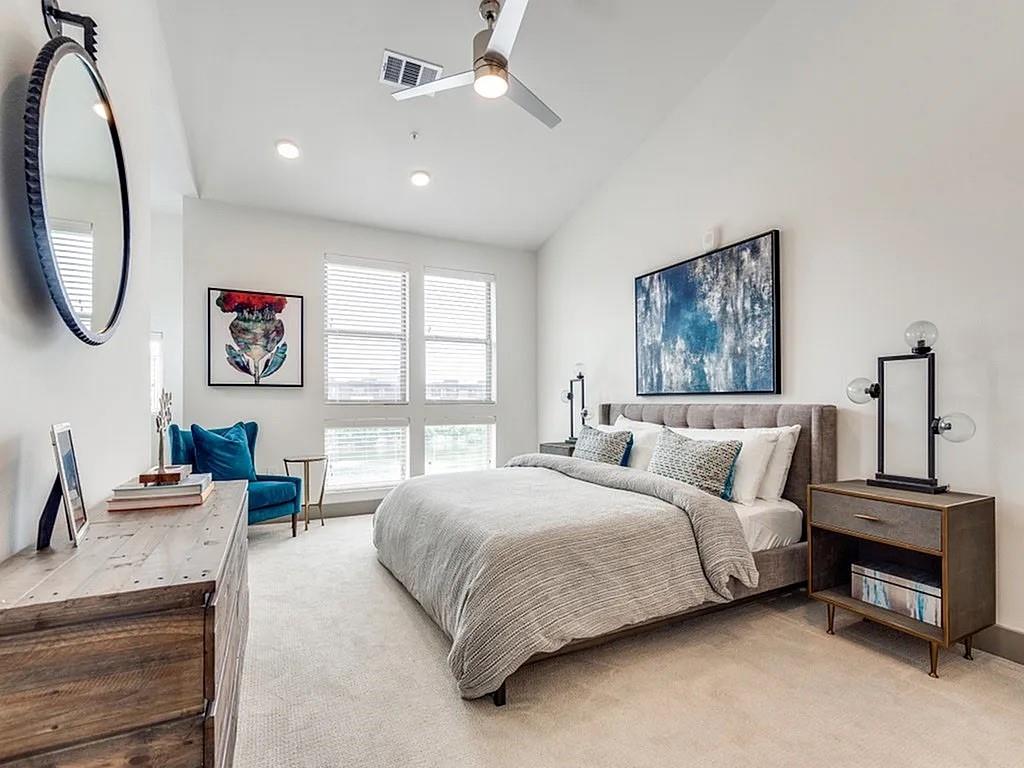 4020 McEwen Road, Unit 9123 Farmers Branch, TX 75244 - Photo 3 of 20 a bedroom with a bed a mirror and a large window