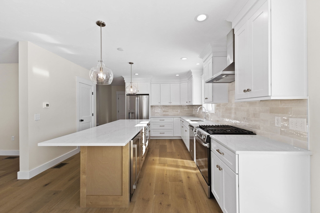 1 Haystack Lane Berkley, MA 02779 - Photo 5 of 33 a kitchen with stainless steel appliances a stove a sink a refrigerator a center island and a wooden floor