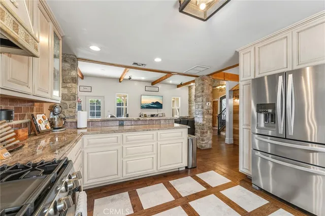 a kitchen with stainless steel appliances granite countertop a refrigerator and a stove top oven
