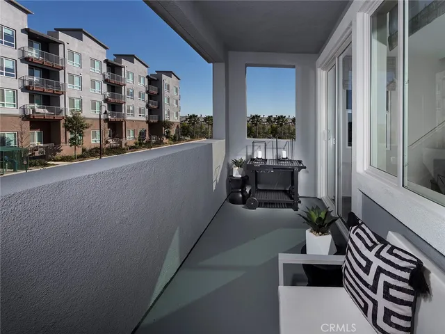 a balcony with chairs and a potted plant