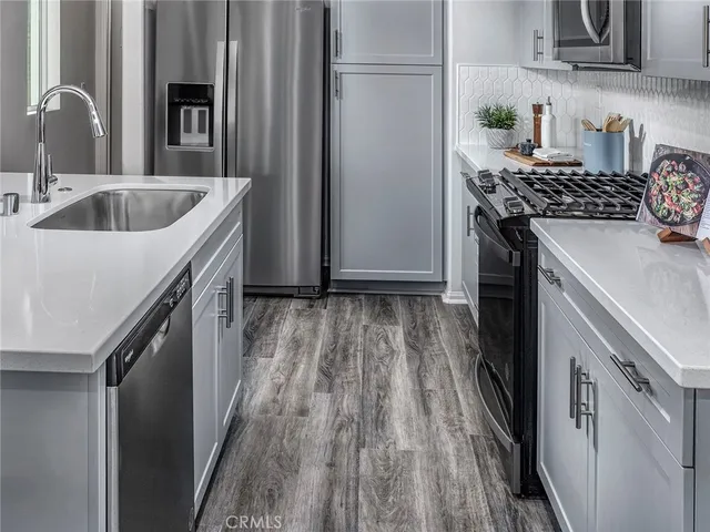 a kitchen with granite countertop a sink stove and refrigerator