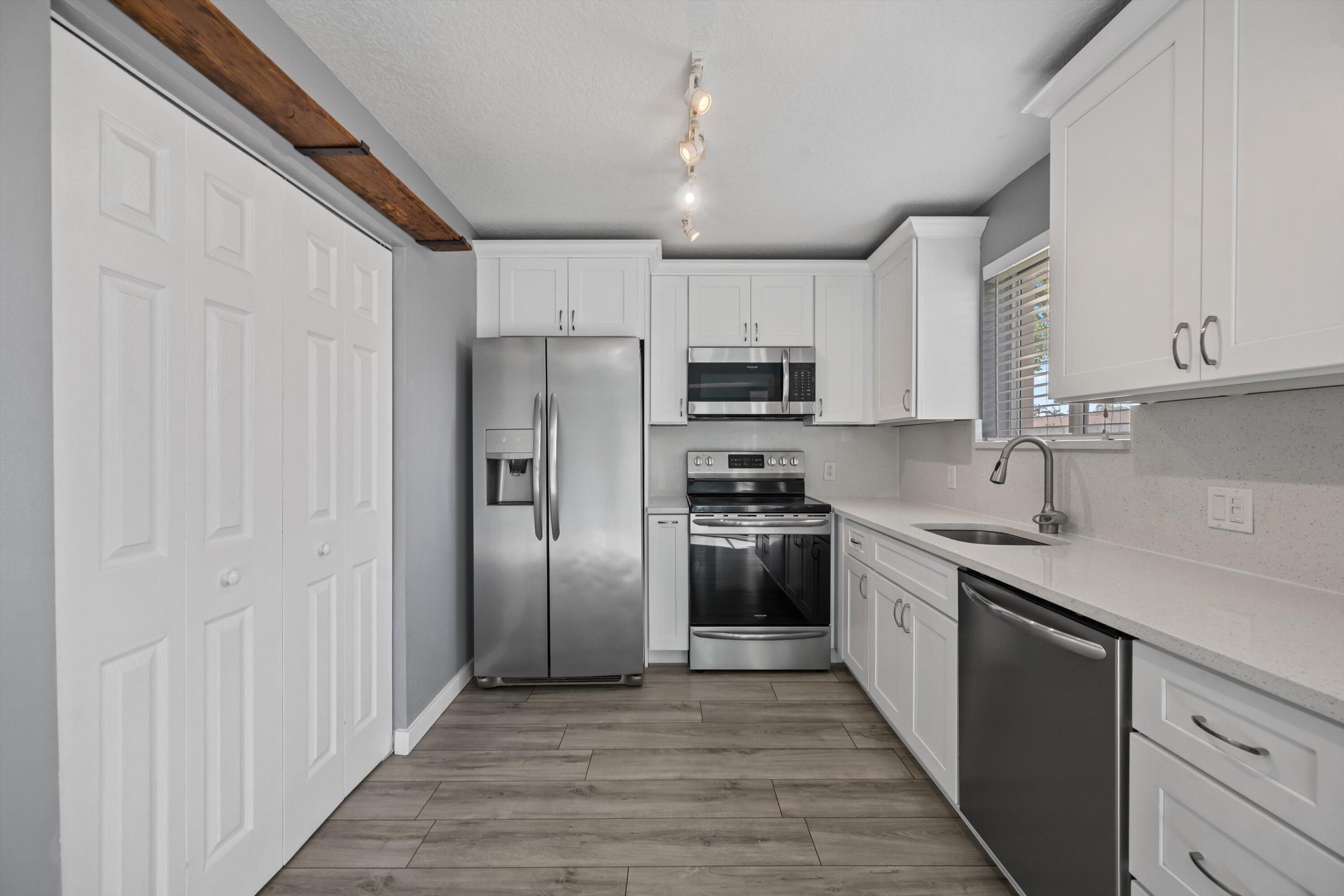 3486 Briar Bay Boulevard, Unit 101 West Palm Beach, FL 33411 - Photo 14 of 46 a kitchen with stainless steel appliances granite countertop a refrigerator and a sink