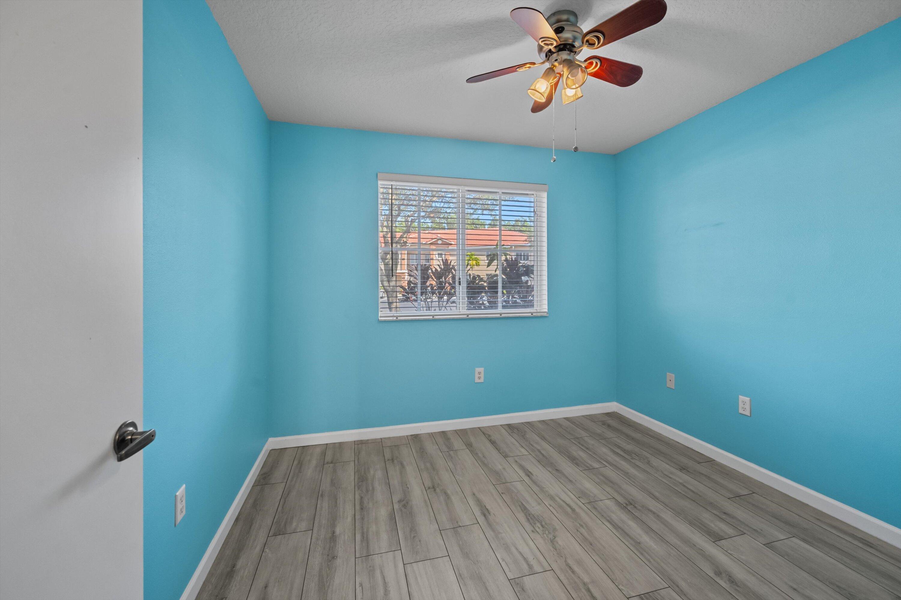3486 Briar Bay Boulevard, Unit 101 West Palm Beach, FL 33411 - Photo 18 of 46 wooden floor in an empty room with a window