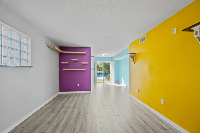 a view of a room with wooden floor and a ceiling fan