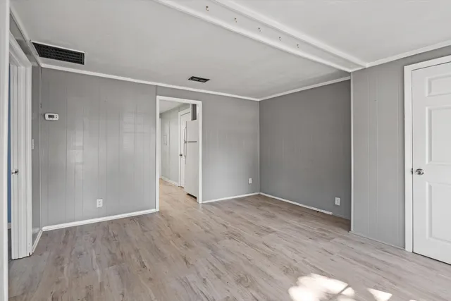 a view of an empty room with wooden floor
