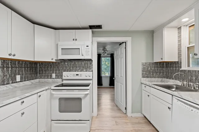 a kitchen with white cabinets sink and stainless steel appliances