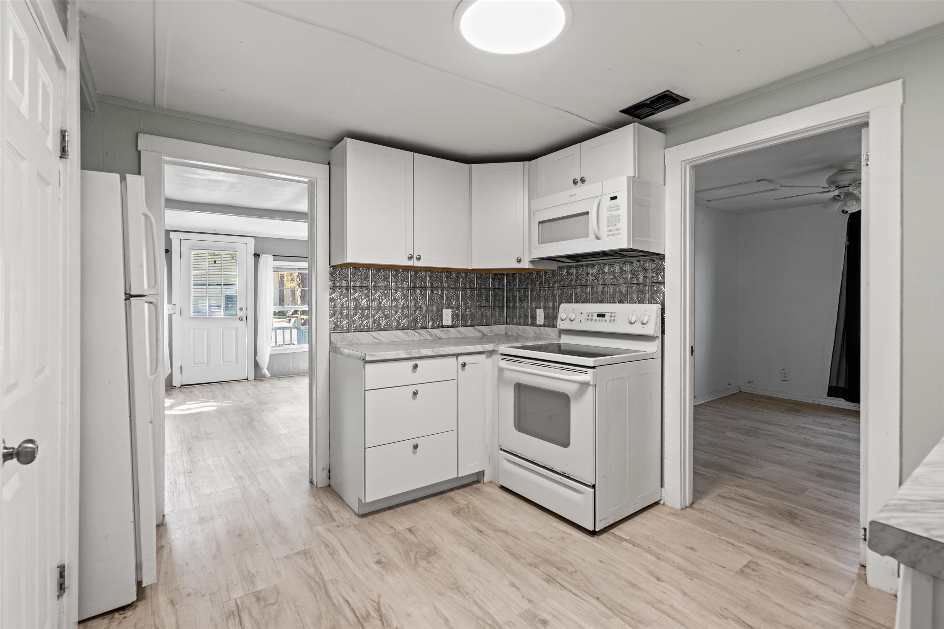 4588 First Avenue St. Augustine, FL 32095 - Photo 7 of 25 a kitchen with stainless steel appliances white cabinets and wooden floor