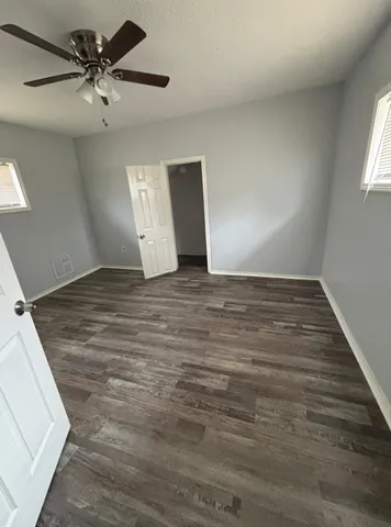 an empty room with fan and windows