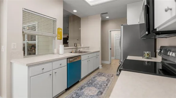 a large white kitchen with stainless steel appliances