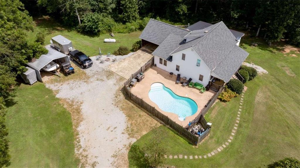 an aerial view of a house with a swimming pool and outdoor seating