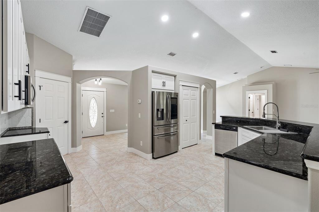 4191 Canal Avenue Bunnell, FL 32110 - Photo 9 of 81 a kitchen with granite countertop a refrigerator and a stove