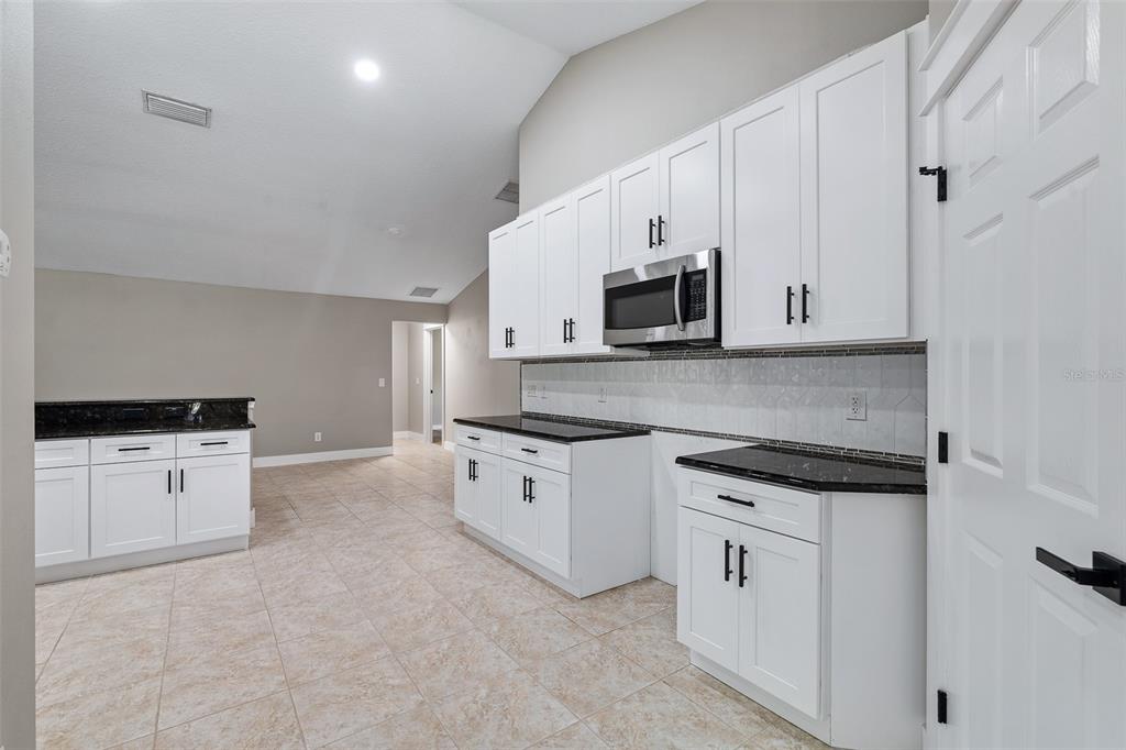 4191 Canal Avenue Bunnell, FL 32110 - Photo 10 of 81 a kitchen with stainless steel appliances granite countertop a stove a sink and a microwave