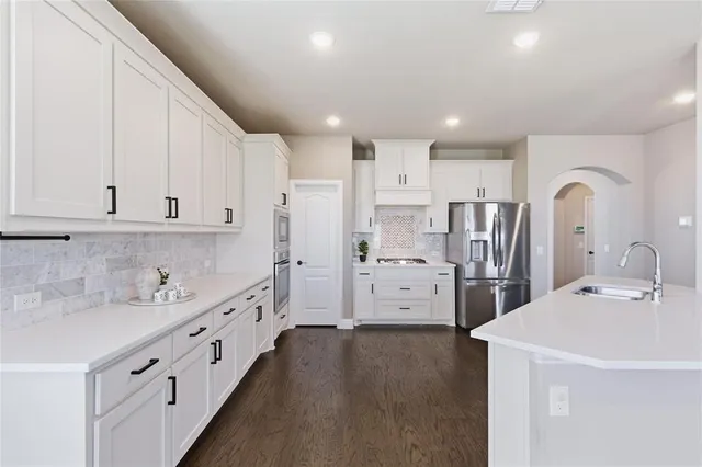a kitchen with refrigerator and cabinets