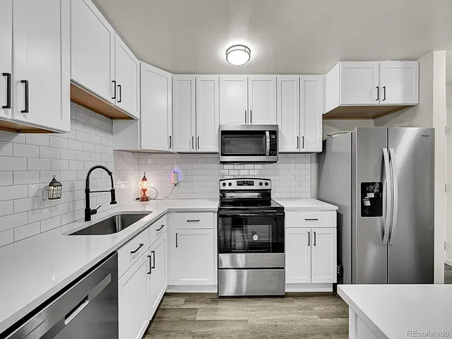 a kitchen with stainless steel appliances a refrigerator and a stove top oven