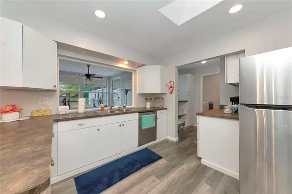 a kitchen with a sink a refrigerator and wooden cabinets
