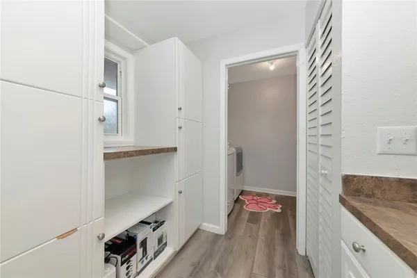 a hallway with a kitchen island with wooden floor