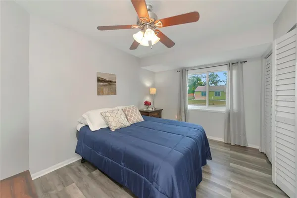 a bedroom with a bed chandelier and a window