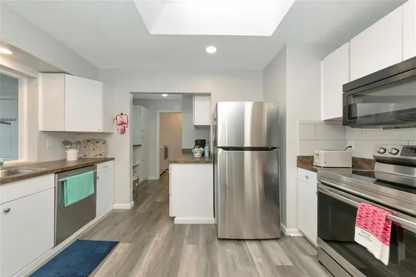 a kitchen with a refrigerator microwave and stove top oven