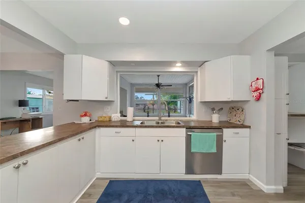 a kitchen with a sink cabinets and wooden floor