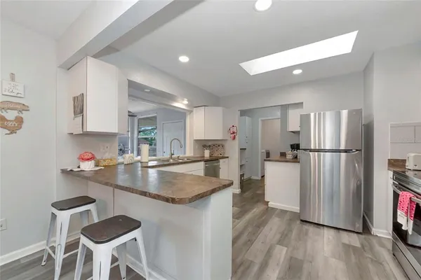 a kitchen with refrigerator and chairs