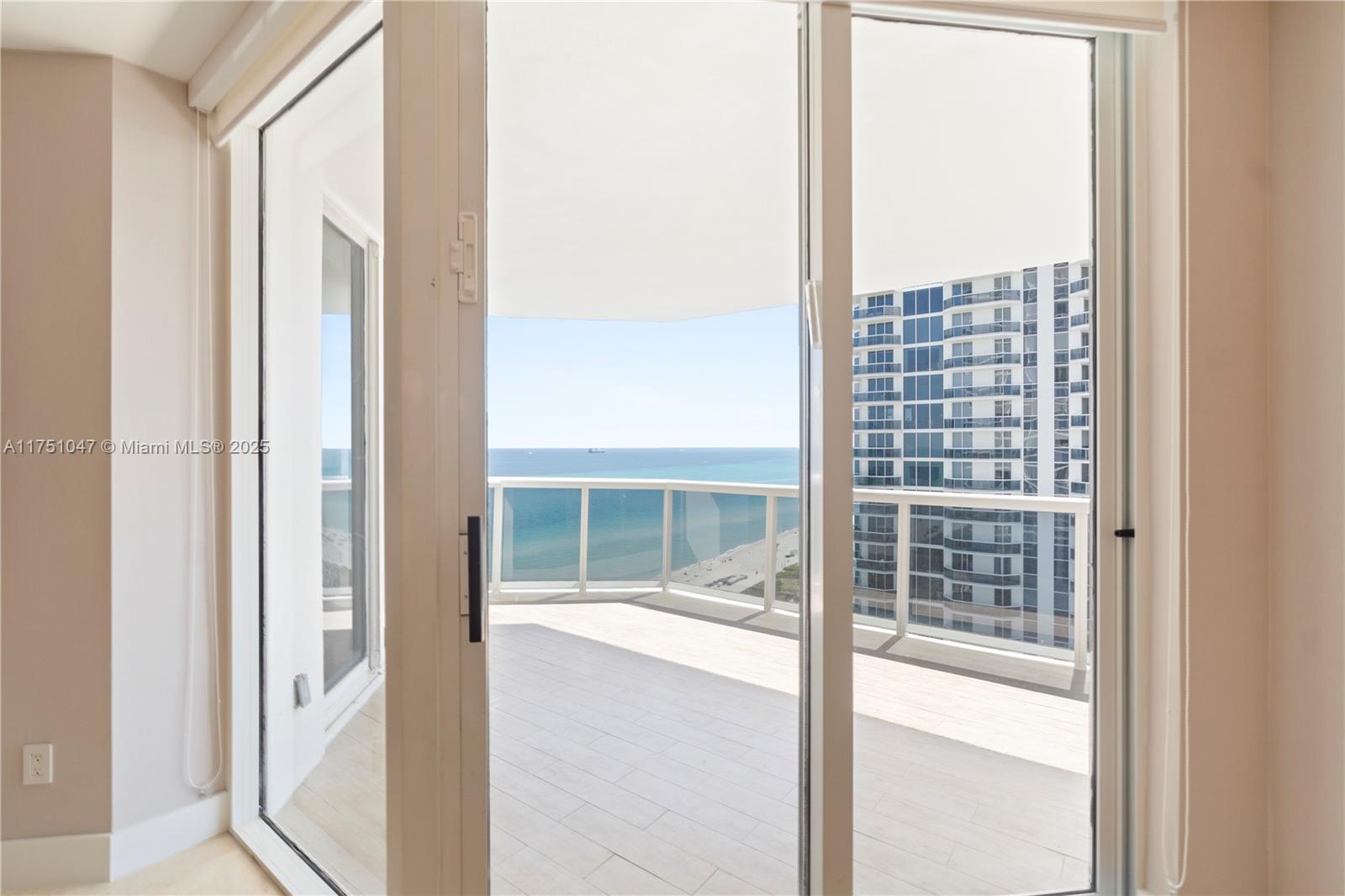 4779 Collins Avenue, Unit 2204 Miami Beach, FL 33140 - Photo 11 of 58 a view of balcony and a floor to ceiling window