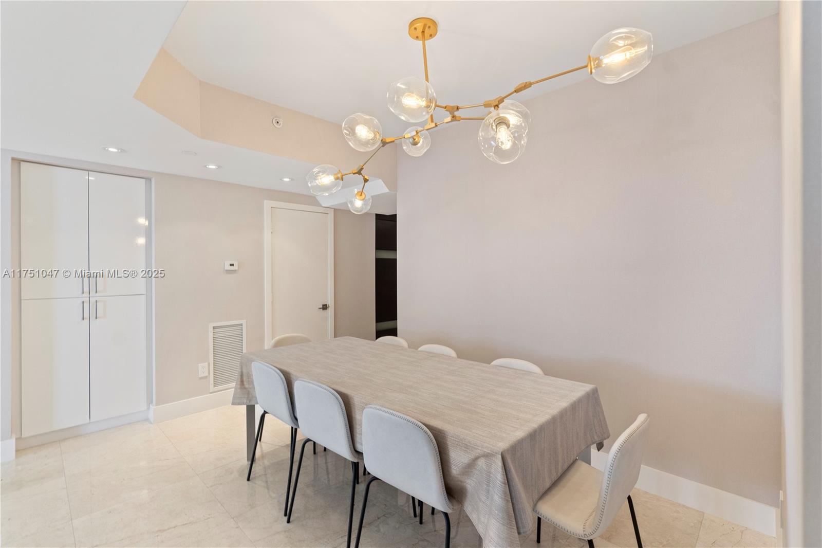 4779 Collins Avenue, Unit 2204 Miami Beach, FL 33140 - Photo 15 of 58 a view of a dining room with furniture and chandelier fan