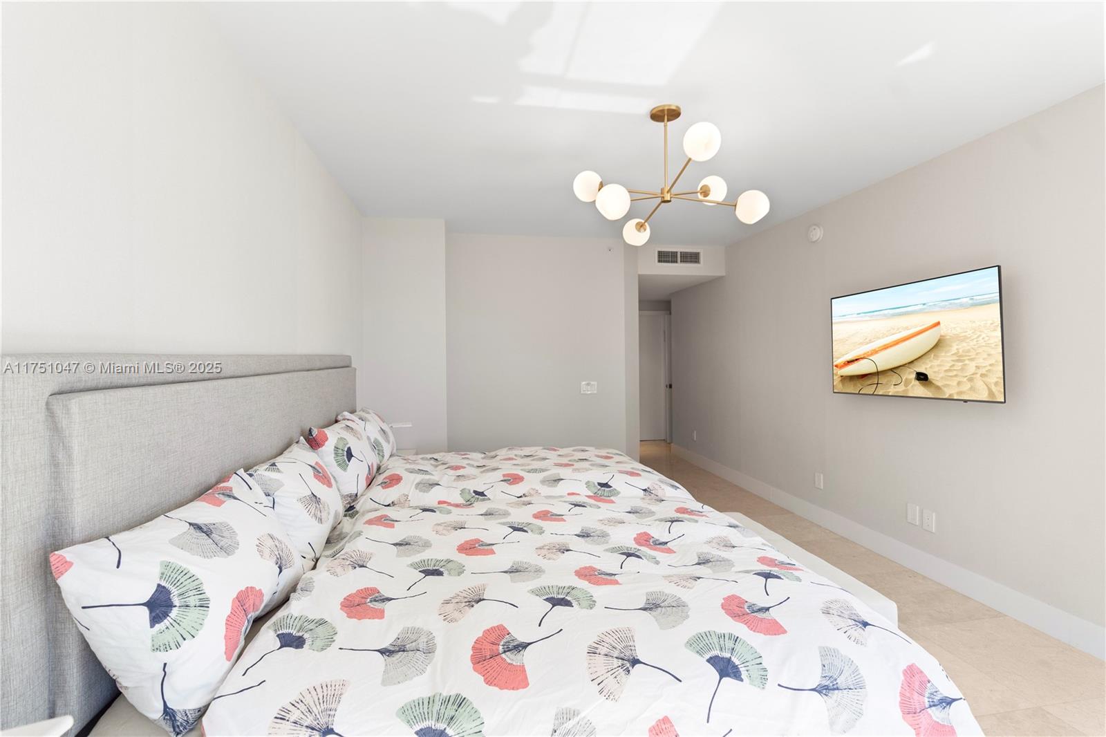 4779 Collins Avenue, Unit 2204 Miami Beach, FL 33140 - Photo 24 of 58 a bedroom with a bed and a chandelier