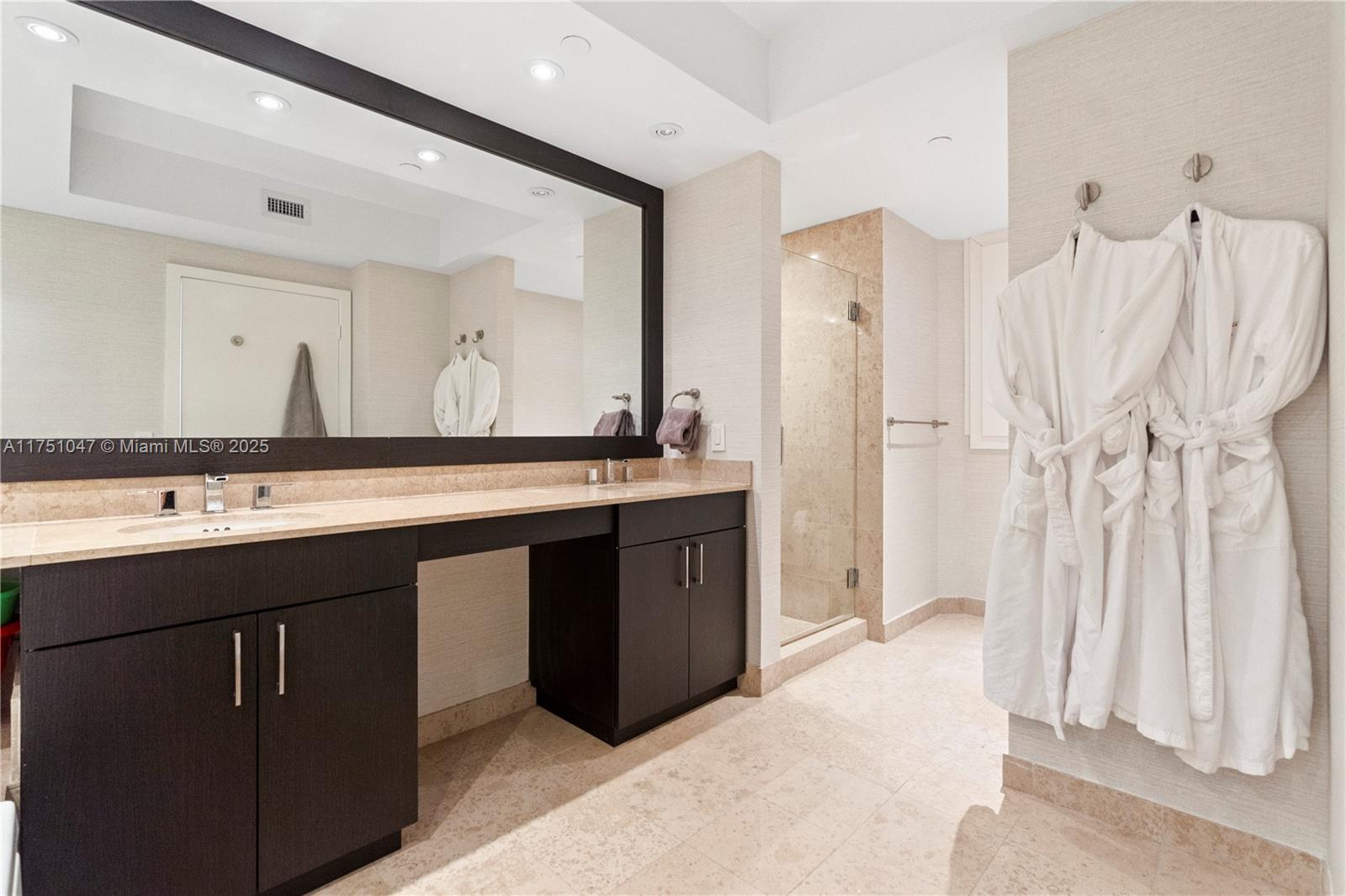 4779 Collins Avenue, Unit 2204 Miami Beach, FL 33140 - Photo 25 of 58 a bathroom with a double vanity sink a and a mirror